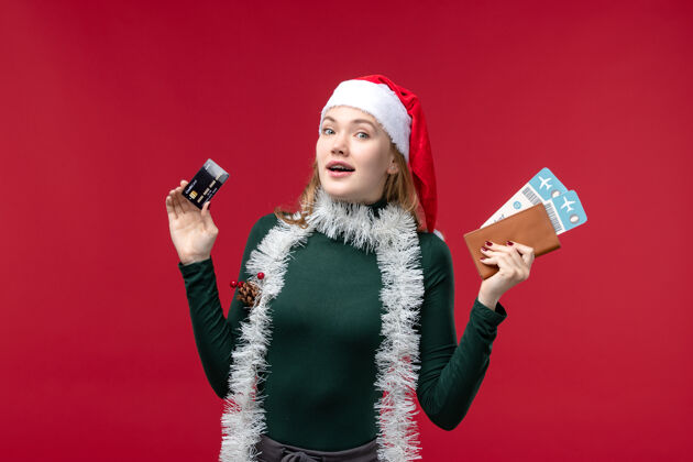 卡片正面图：年轻女性 带着红色背景的银行卡和车票帽子年轻女性圣诞节