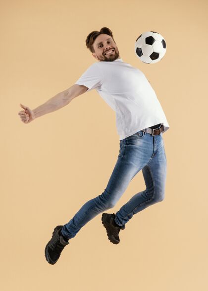 年轻年轻帅哥拿着足球跳起来男人模特跳跃