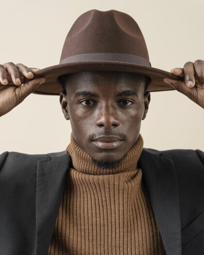 肖像年轻帅哥戴着帽子摆姿势时尚男人模特