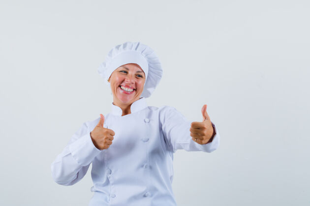 年轻身着白色制服的女厨师竖起大拇指 看上去很乐观学生模型时尚