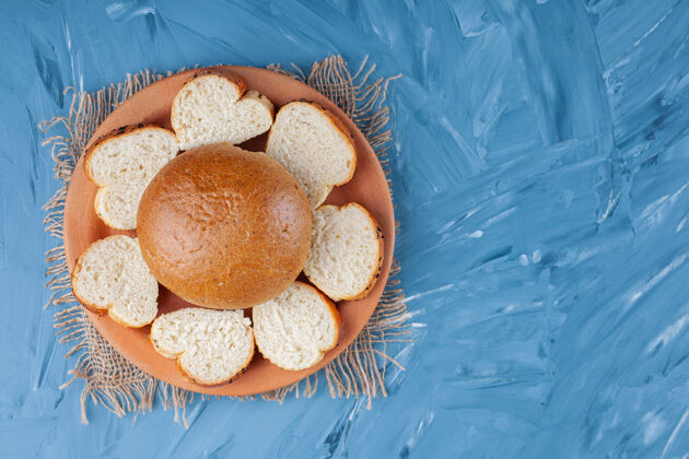 馒头面包和切片面包放在盘子里 蓝色的粗麻布餐巾上面粉酵母美味