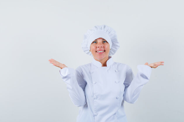 学生女厨师假装拿着或展示白色制服的东西 看起来很自信抱着女人可爱