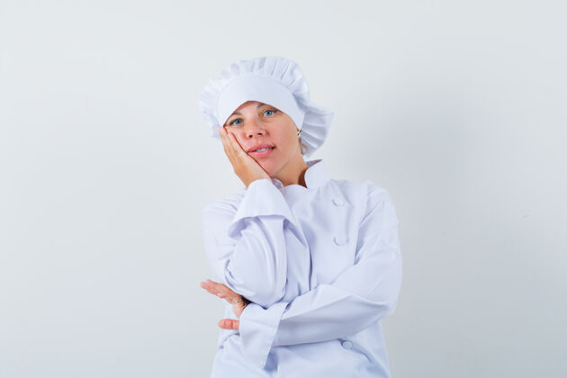 厨师一位身穿白色制服的女厨师手放在脸颊上 看上去很体贴制服女性时尚