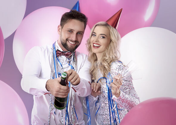乐趣一对年轻夫妇在庆祝新年前夜拥抱发光饮酒