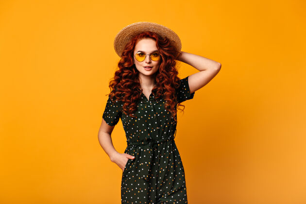 时尚穿着复古服装的姜汁女孩的正面图戴着太阳镜和草帽的漂亮年轻女士的摄影棚照片一个人女人情绪