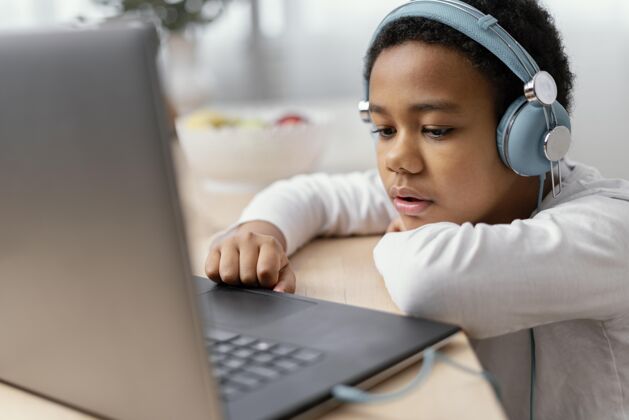 小玩意男孩听音乐和使用笔记本电脑男孩房子技术