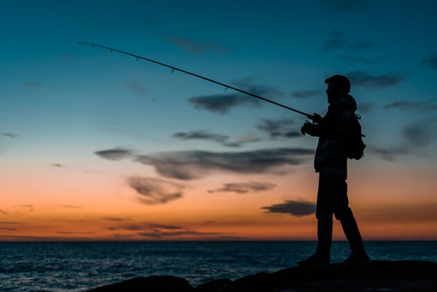 夏日沙滩日落时分在海滩钓鱼的男人的剪影剪影日落男人