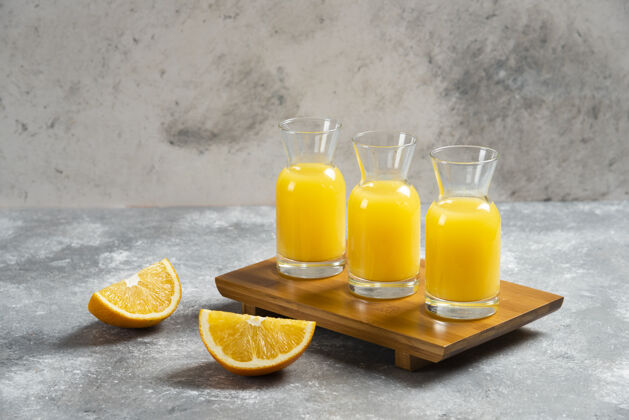 玻璃装橙汁和橙子片的玻璃罐酸木材黄色