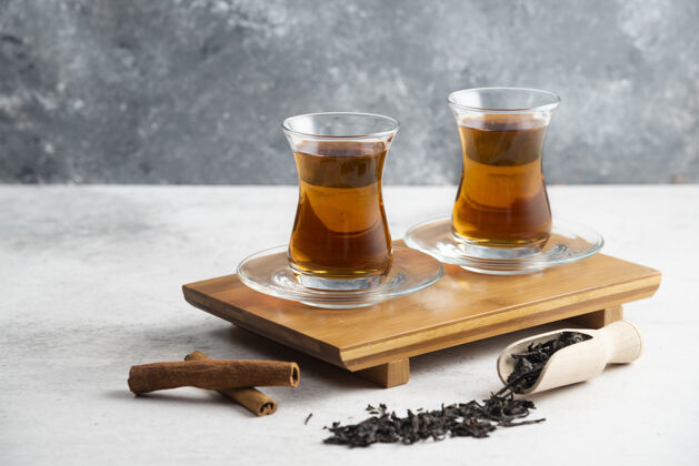 可口两杯肉桂茶和散茶高品质照片糖玻璃木板