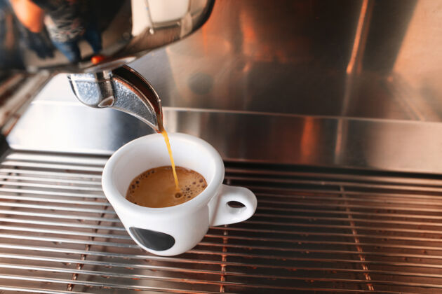 准备从一杯芳香的饮料开始你的一天时尚的黑色浓缩咖啡机冲泡咖啡 在咖啡馆拍摄现代专业咖啡