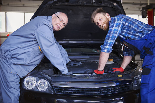 发动机修理工在车间里修理汽车眼镜专业职业实习生
