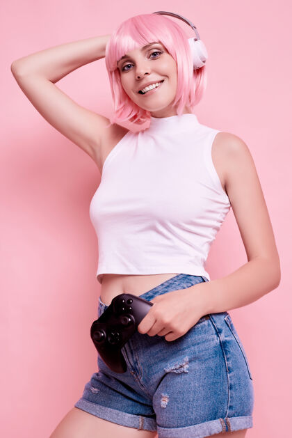 魅力粉红头发的美女肖像在耳机里欣赏音乐时尚在线欢乐
