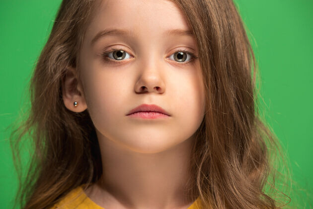 美女严肃 悲伤 怀疑 体贴的少女站在绿色工作室肖像表情年轻
