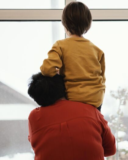 团结奶奶和孙子透过窗户看的后视图小孩子祖父母