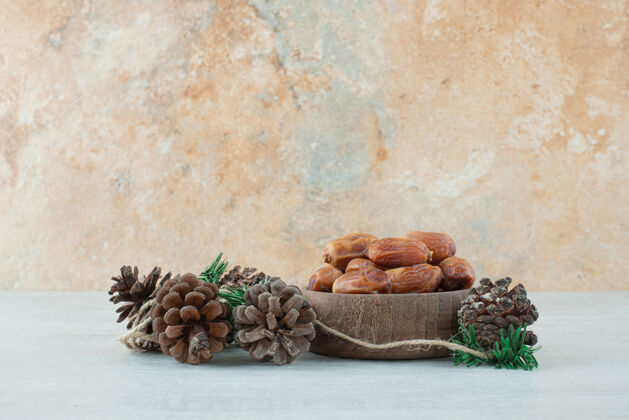 可口一小碗干果和松果放在大理石背景上高质量的照片食物碗松果