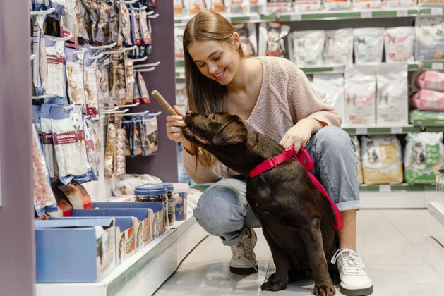 动物可爱的狗和主人在宠物店商店品种消费