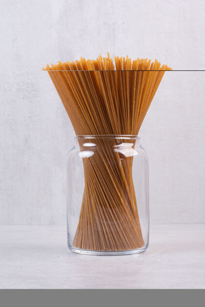 意大利面生的棕色意大利面放在玻璃罐里生的食品面条