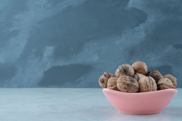 可口在大理石背景上放满坚果的粉红色小盘高质量照片吃食物粉色