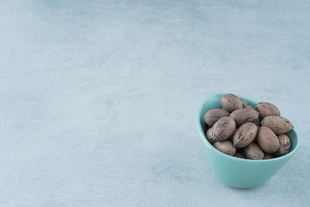 健康在大理石背景上放满坚果的蓝色小盘高质量照片坚果可食用小