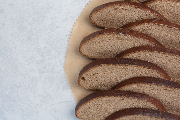 黑麦黑面包片在纸上高质量的照片面包房面包皮棕色
