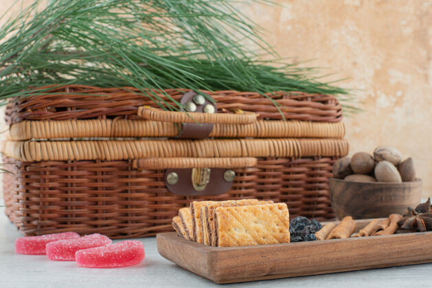 糕点一个手提箱和一个装满饼干的木板 八角茴香和肉桂棒放在大理石背景上高质量的照片糖糖果糖果
