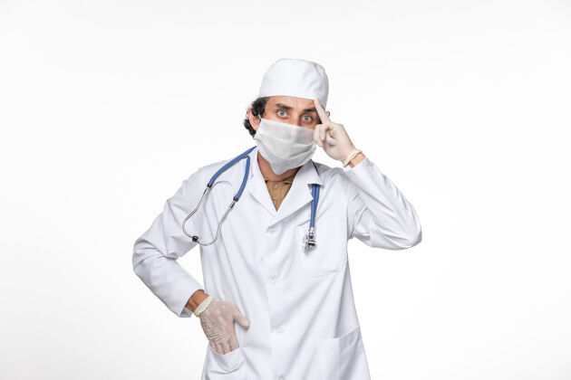 面具正面图戴口罩的男医生穿着医疗服 以防感染冠状病毒——关于白墙飞溅病毒冠状病毒大流行的思考防护正面医学