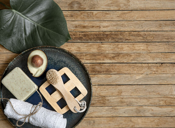 木材水疗用肥皂 鳄梨毛巾 刷子和叶子组成的木质表面复制空间手工叶子皮肤护理