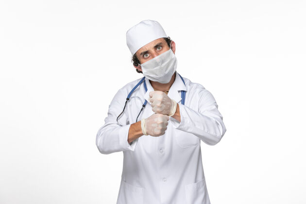 人正面图身穿医疗服的男医生戴着无菌口罩 以防白墙病毒冠状病毒大流行面具查看男性
