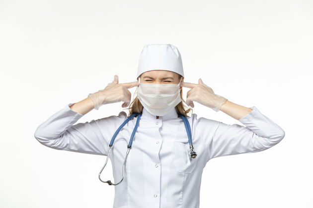 视野正面图女医生穿着白色医疗服 戴着无菌口罩 因冠状病毒闭上耳朵白墙疾病冠状病毒-大流行性疾病冠状病毒预防到期套装