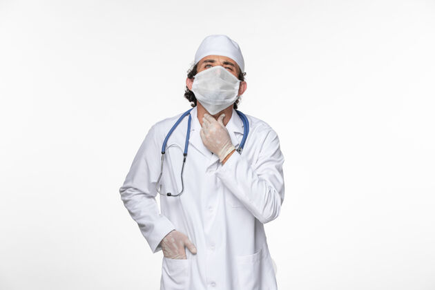 套装正面图男医生穿着医疗服 戴着无菌口罩 以防冠状病毒感染轻白壁病毒大流行疾病男性防护穿戴