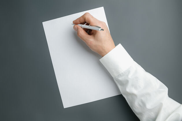 信息男性手持式钢笔 在灰色墙上的空白纸上书写文字或设计用于联系 广告或商业 金融 办公 采购的空白模板复制空间文本卡片联系人