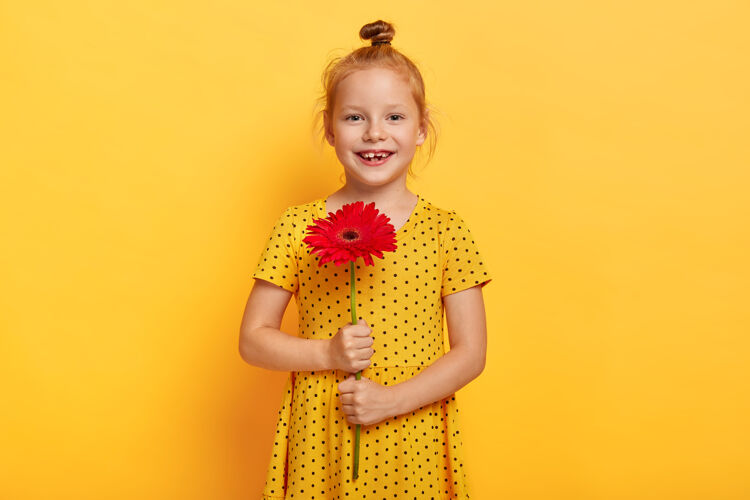 红发美丽的小红发女孩和穿着黄色裙子的花合影非洲菊喜悦衣服