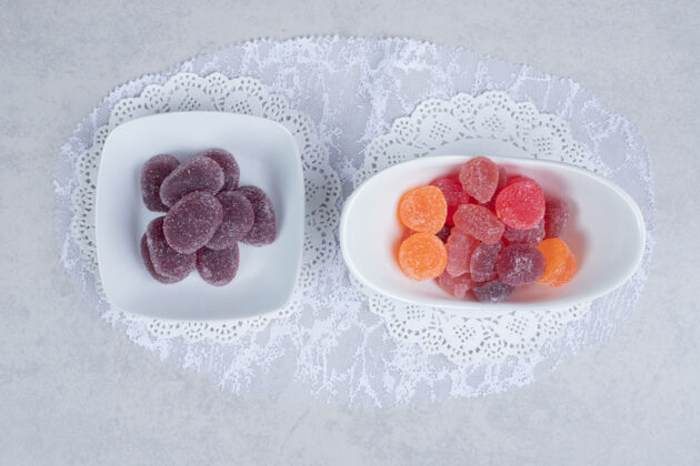 含糖白色桌子上摆着一碗碗五颜六色的果酱高质量的照片美味果冻糖果