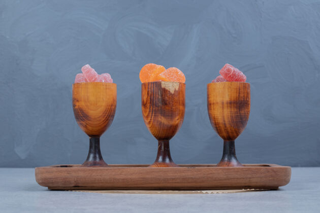 糖果五颜六色的果酱在木盘上的木杯高品质的照片各种含糖美味