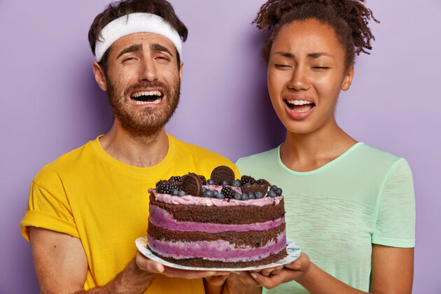 哭一对悲伤的活跃夫妇与一个大蛋糕合影的特写镜头不健康甜点膳食