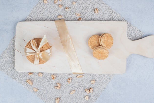 蝴蝶结一堆节日饼干和花生放在木板上高质量的照片丝带面包房饼干