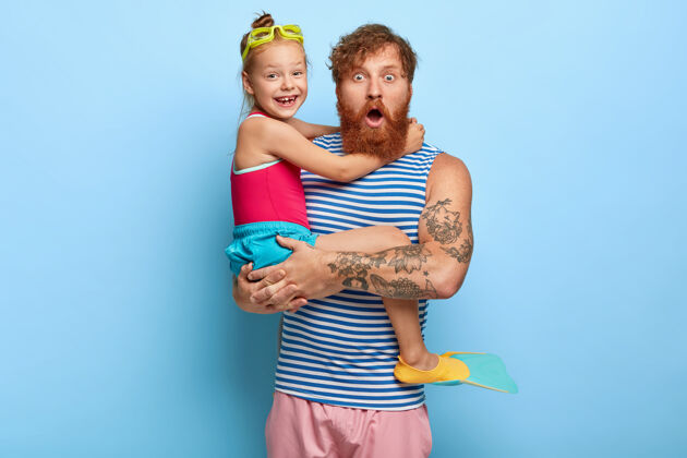 震惊惊呆了的姜爸爸和女儿穿着游泳衣摆姿势鳍玩耍红发
