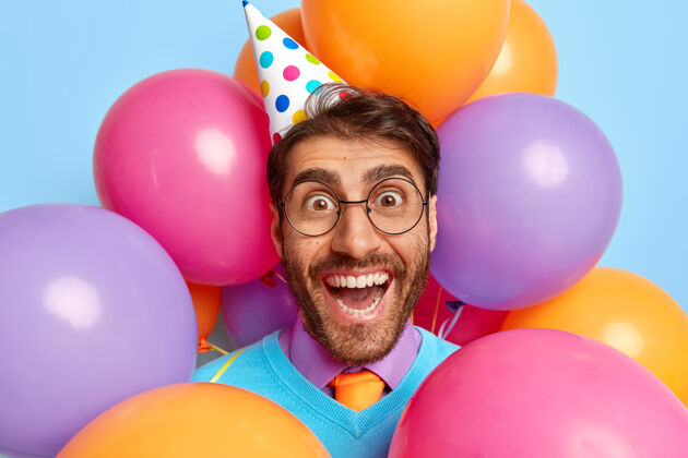 兴奋快乐有趣的家伙被派对气球包围快乐男人五颜六色