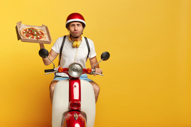 耳机有目的的英俊男司机骑着红色头盔的摩托送比萨饼姿势T恤房子