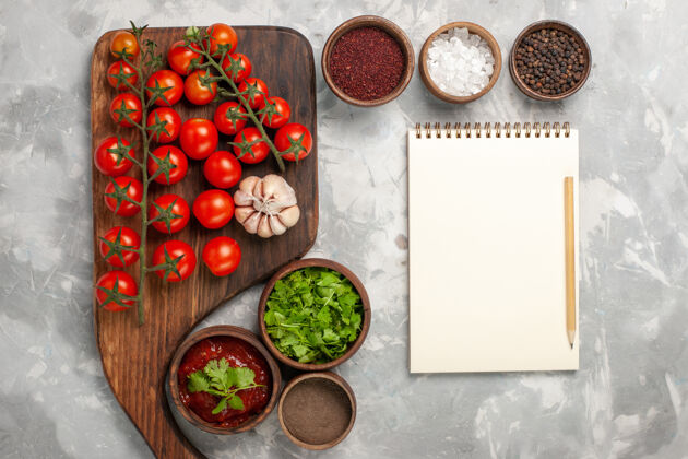 蔬菜顶视图新鲜的樱桃西红柿与调味品记事本和绿色的白色表面记事本晚餐西红柿