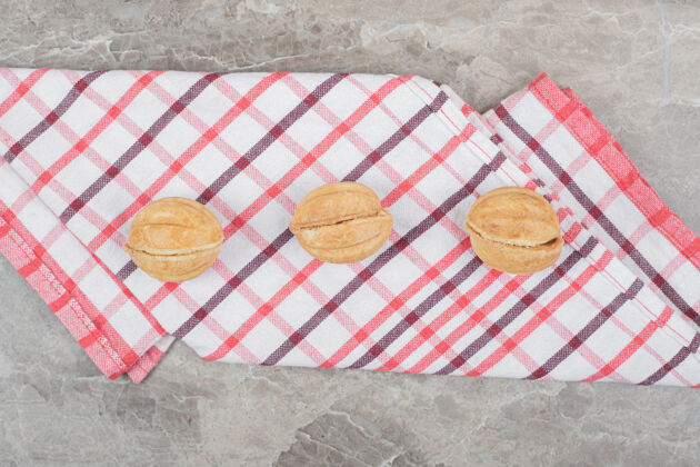 自制五颜六色桌布上的核桃形饼干高品质照片焦糖饼干填充