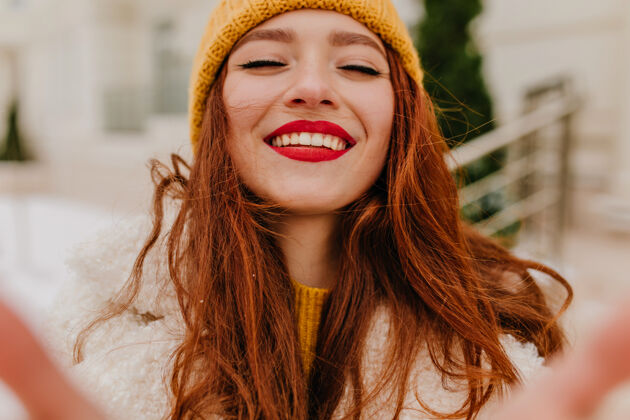 兴奋迷人的长发女子戴着帽子笑着闭着眼睛热情的姜姑娘在冬天表达幸福的户外照片微笑模特红发