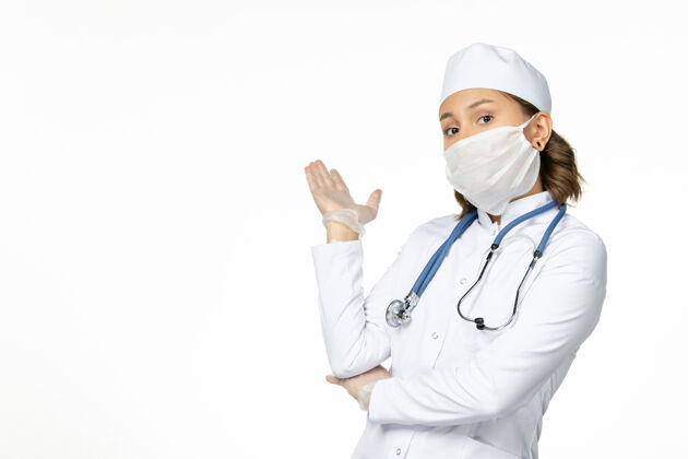 手套正面图年轻女医生戴着无菌口罩和手套 白色办公桌上有冠状病毒医疗护士冠状病毒