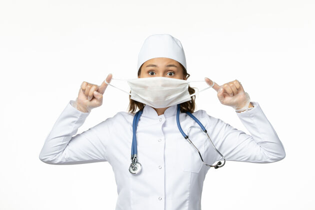 诊所正面图年轻女医生手持防护面罩因白色表面有冠状病毒专业病毒制服