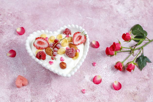 特写心形碗里放着玉米片和浆果的酸奶浆果浪漫情人节