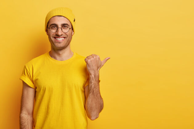 朋友横视快乐快乐的家伙 带着牙齿般的微笑 手指着拇指 有着友好的表情水平黄色肖像