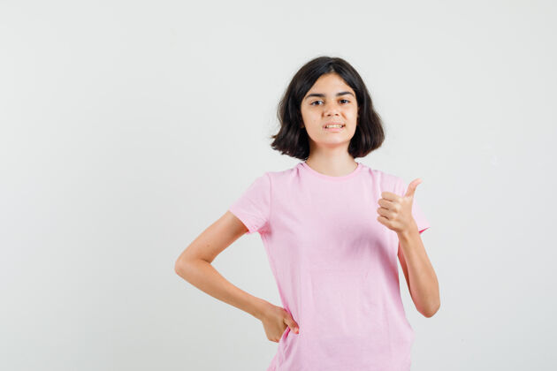成人照片中的小女孩穿着粉色t恤向上竖起大拇指 看上去很快乐青少年可爱视图