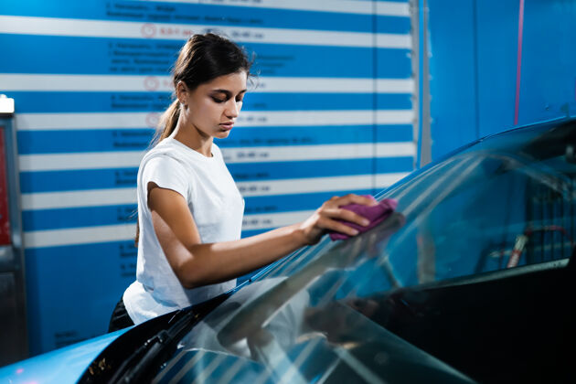 擦亮一个年轻女人在洗车的镜头保养手车