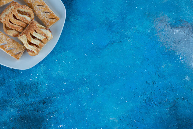 不健康的食物美味的饼干与果酱的盘子上 在蓝色的背景高品质的照片烘焙曲奇美味
