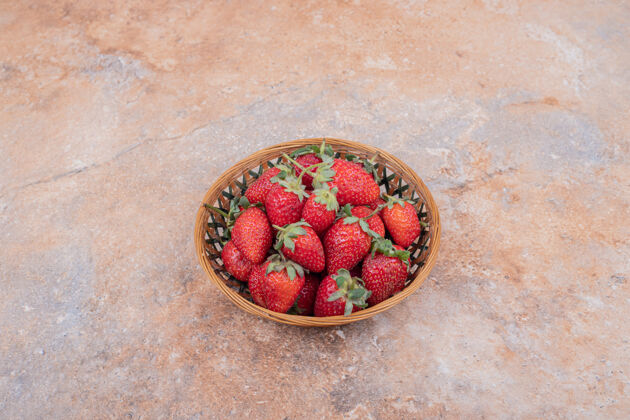 热带红色草莓放在大理石上的陶碗里水果极简新鲜